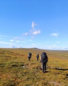 Vaeltajia rinkka selässä tunturissa.