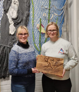 Ilona Torsti ja Ida Erling, jonka kädessä tunnustuspalkinto puinen taulu.